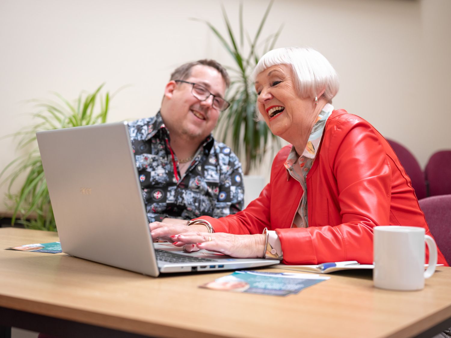 A volunteer and a learner over a laptop at the Centre